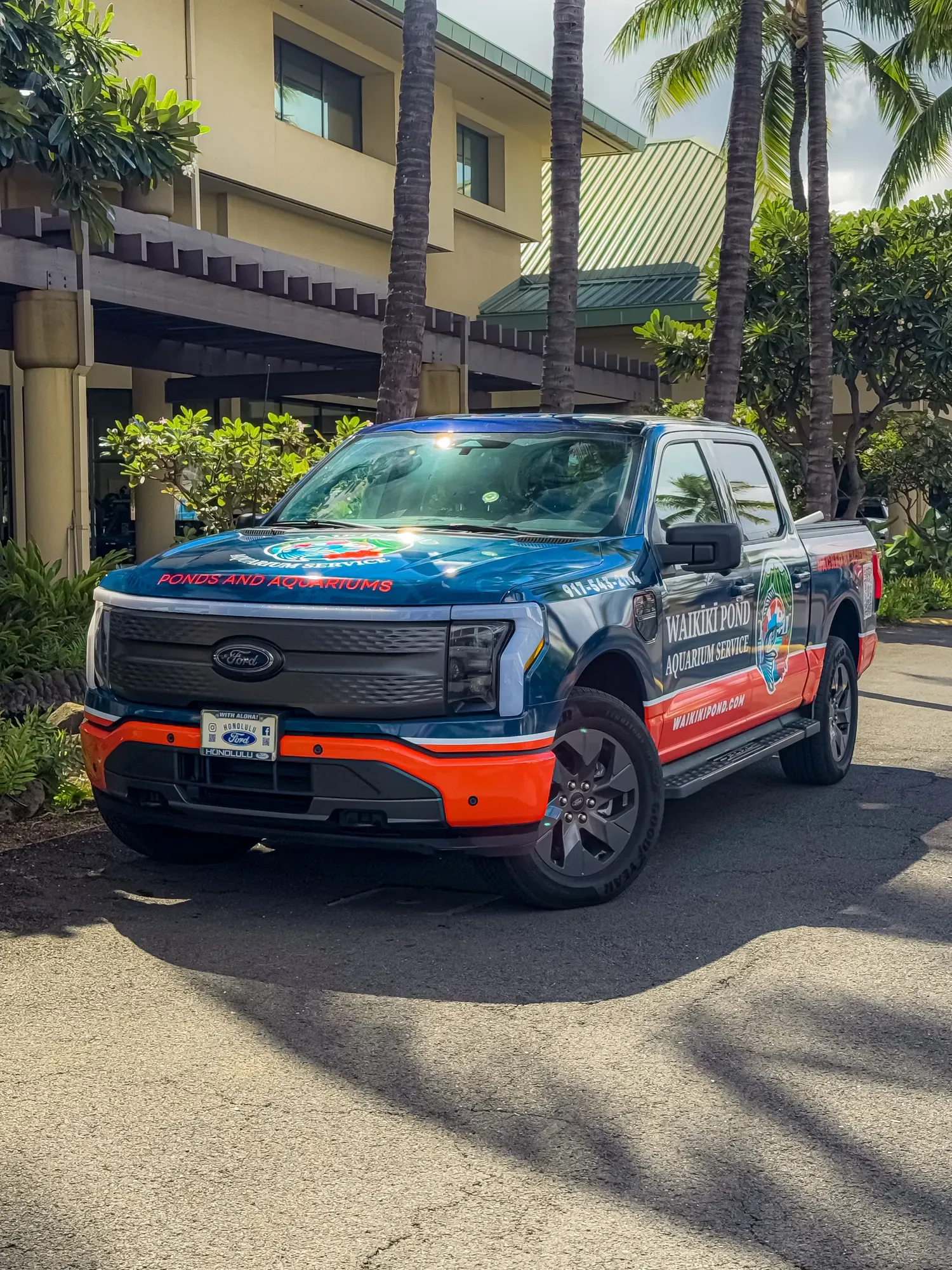 The wrapped F-150 Lightning in three-quarter view, koi badge across the door and the science-backed line along the bed.