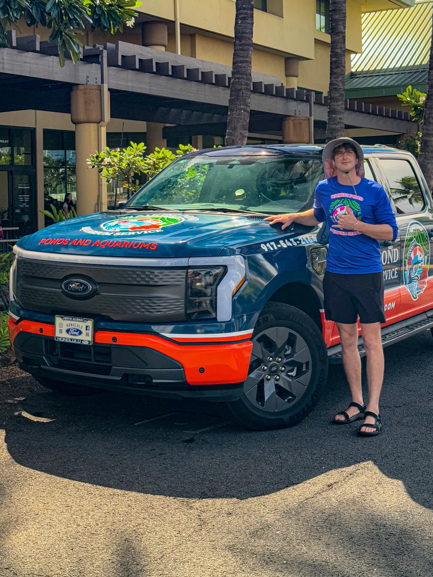 The owner beside the front of the wrapped truck.